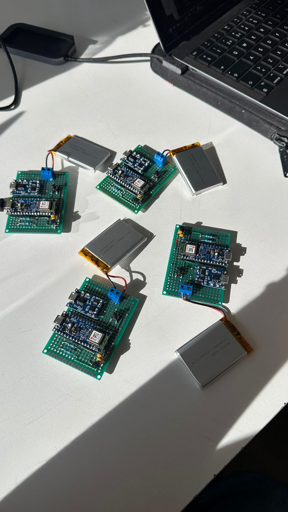 ElectroCap prototype circuit boards with batteries and IMU modules on a desk